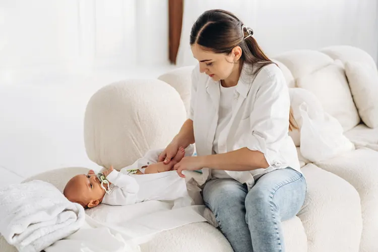 Parent changing baby on fabric